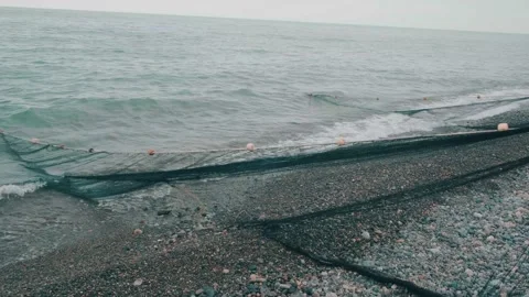 Fishermen pull nets from the sea on a beach with dramatic sky on Black sea Stock Footage 196925589
