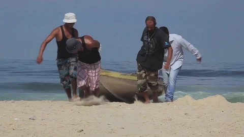 Fishermen pulling the boat to the beach Stock Footage 148626461