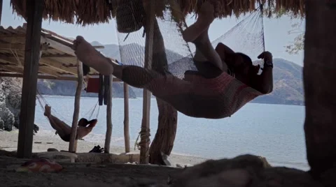 Fishermen relaxing on hammock Stock Footage 58857902