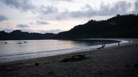 Fishermen returning from sailing using small boats on the beach Stockbeeldmateriaal 305840156