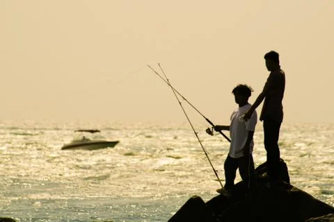 Fishermen on rocks Stock Photos