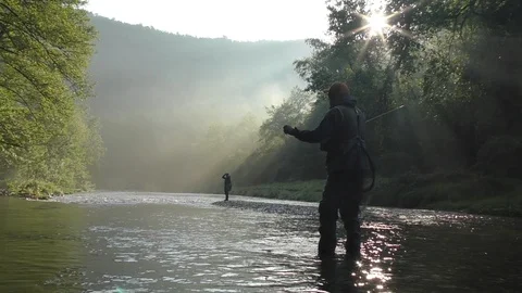 Fishermen silhouettes catch fish on river in early morning Stock Footage 101925069