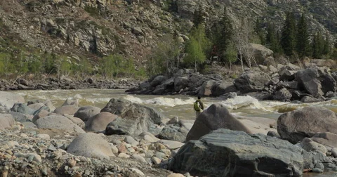 Fishermen on the stones catch fish in the rough water. Stock Footage 62998308