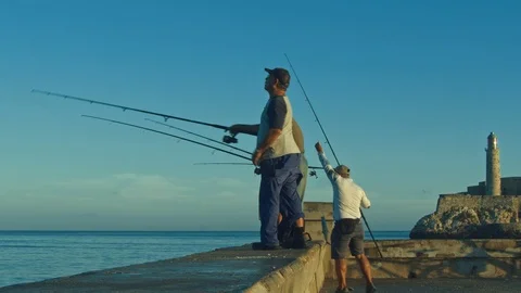 Fishermen at sunrise in the malecon of Havana Stock Footage