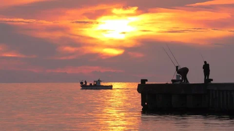 Fishermen at sunset on the pier Stock Footage 95044440