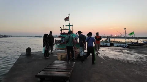 Fishermen unload nets at sunset's gentle glow Видео 345138659