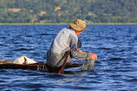 Fishermen working checking their nets on the waters of Inle Lake. Stock Photos