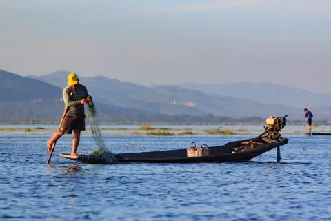 Fishermen working checking their nets on the waters of Inle Lake. Stock Photos