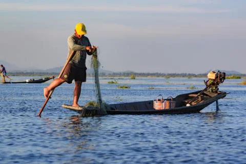 Fishermen working checking their nets on the waters of Inle Lake. Stock Photos