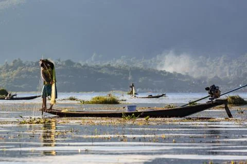 Fishermen working checking their nets on the waters of Inle Lake. Stock Photos