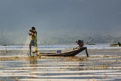 Fishermen working checking their nets on the waters of Inle Lake. Stock Photos
