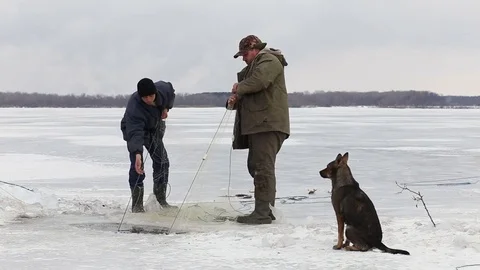 Fishermens pull fish out of the hole in a frozen pond. Winter fishing 스톡 동영상 82395747