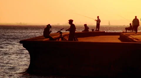 Fishers and cyclists in sunset Stock Footage 68704211