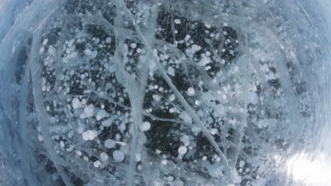 Fisheye frozen methane bubbles in winter cracked ice Baikal lake nature landmark Stock Footage 165663449