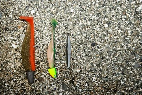 Fishing baits lying in large-grained sand Foto stock