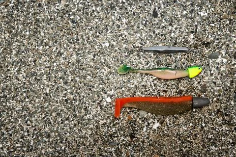Fishing baits lying in sand Stock Photos