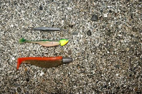 Fishing baits lying in sand Stock-Fotos