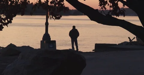 Fishing on Bank of a River - Sunset Stock Footage 82807075
