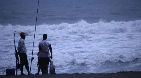 Fishing on a Beach with Rough Waves Stock Photos