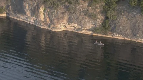 Fishing by the bluff of the lake Stockbeeldmateriaal 115062276