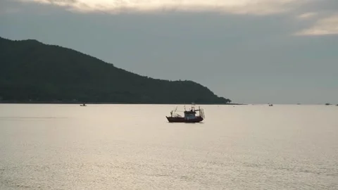 Fishing Boat Floats Peacefully in Middle of Calm Sea at Sunset Stock-Footage 307683407