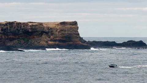 Fishing boat going past the right side of St. Lawrence Rocks, Australia. Stock Footage 87851540