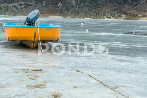 Fishing boat on ice covered river. Stock Photos