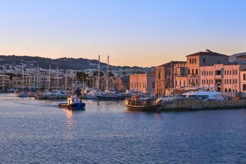 Fishing boat leaving Old Venetian port of Chania, Crete, Greece at sunrise Stock Photos