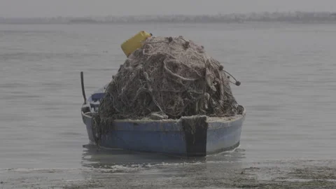 A fishing boat loaded with nets drifting in shallow waters Stock Footage 243820695