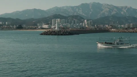 Fishing boat passing in front of a lighthouse. Sokcho, South Korea Stock Footage 260212386