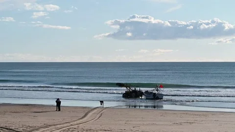 Fishing boat pulled ashore by tractor Stock Footage 329216503