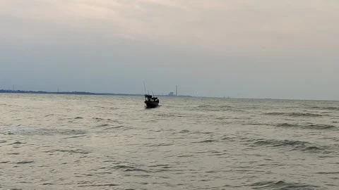 A fishing boat swayed by small waves heading towards the harbor Stock Footage 277122846