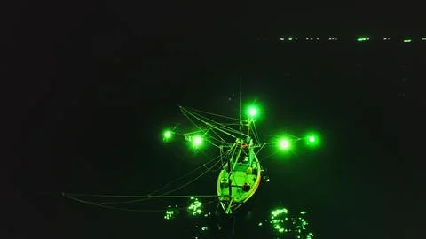 Fishing boat using green lights illuminating the sea at night in Koh Phangan Stock-Fotos