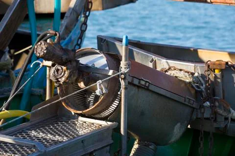Fishing boats in harbor - machine for the processing of clams Фото