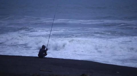 Fishing on a Cloudy Beach Stock Photos