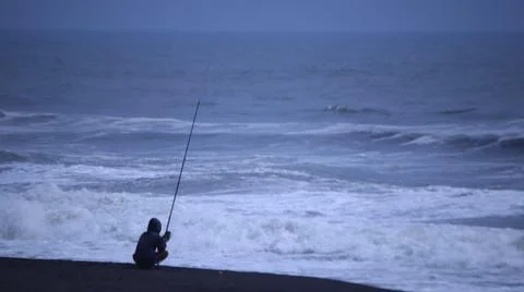 Fishing on a Cloudy Beach Stock Photos