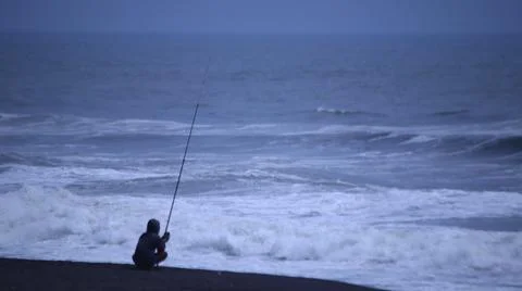 Fishing on a Cloudy Beach Stock Photos