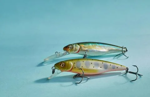 Fishing equipment. Two multi-colored plastic fishing wobblers on a blue backg Foto stock
