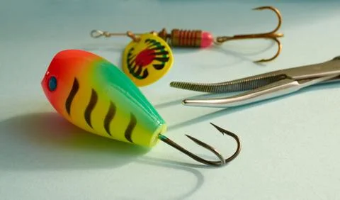 Fishing equipment. Two multi-colored fishing lure and scissors to extract the Stock Photos