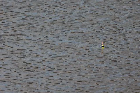 Fishing float bobber on a rippled water surface with copy space Stock Photos