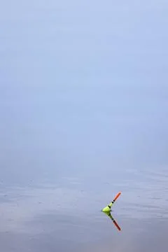 Fishing float on calm water surface Stock Photos