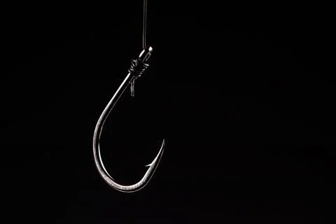 Fishing hook on a black background. trap, catch on, risk. Business concept id Foto stock