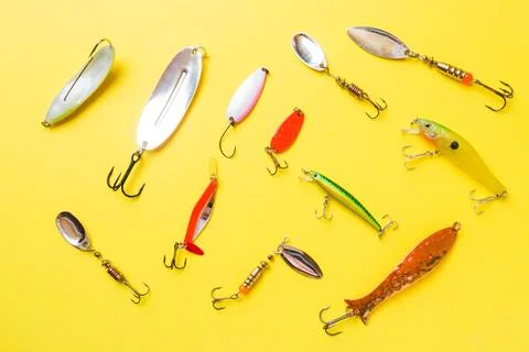 Fishing hooks and baits in a set for catching different fish on a yellow ba.. 写真素材
