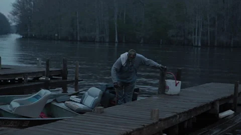 Fishing on a lake at dawn with a man pulling nets from the water Stock Footage 327957984