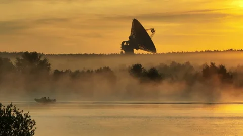 A fishing motorboat quickly sails through the water of a calm river at sunrise. Stock-Footage 219516444