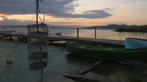 Fishing net and small boat along a pier at sunset in Florianopolis, Brazil Stock Footage 231545882