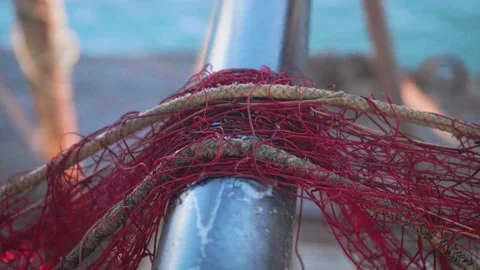 Fishing net close up, harbour workers at work. Fishermen arranging red fishnets Stock Footage 137864721