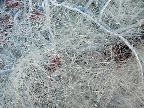 Fishing net closeup with tangled threads and red floats creating abstract b.. 스톡 사진