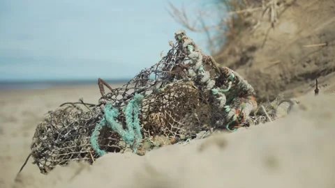 Fishing net laying on beach in the sand Stock Footage