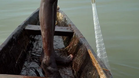 A fishing net pulled out by African fisherman from the water in a canoe Stock Footage 71161016
